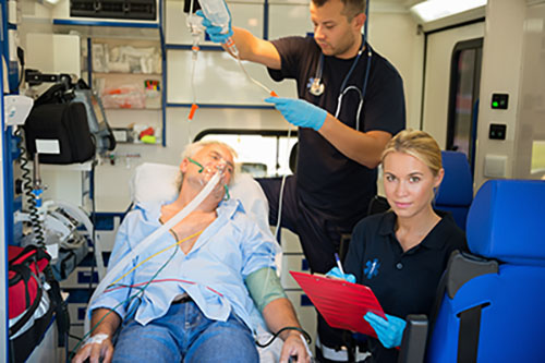 paramedics treating elderly man